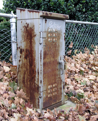 Rusty locker at the edge of a field.
