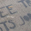 ‘FREE TRADE COSTS JOBS + LIVES’ painted on a sidewalk.