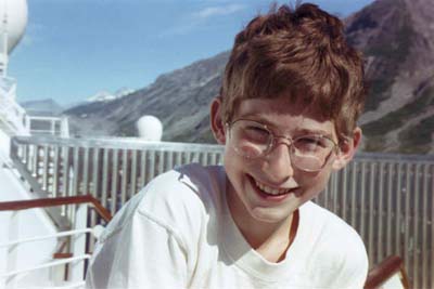 Pale young Aaron, huge goofy glasses, broad smile.
